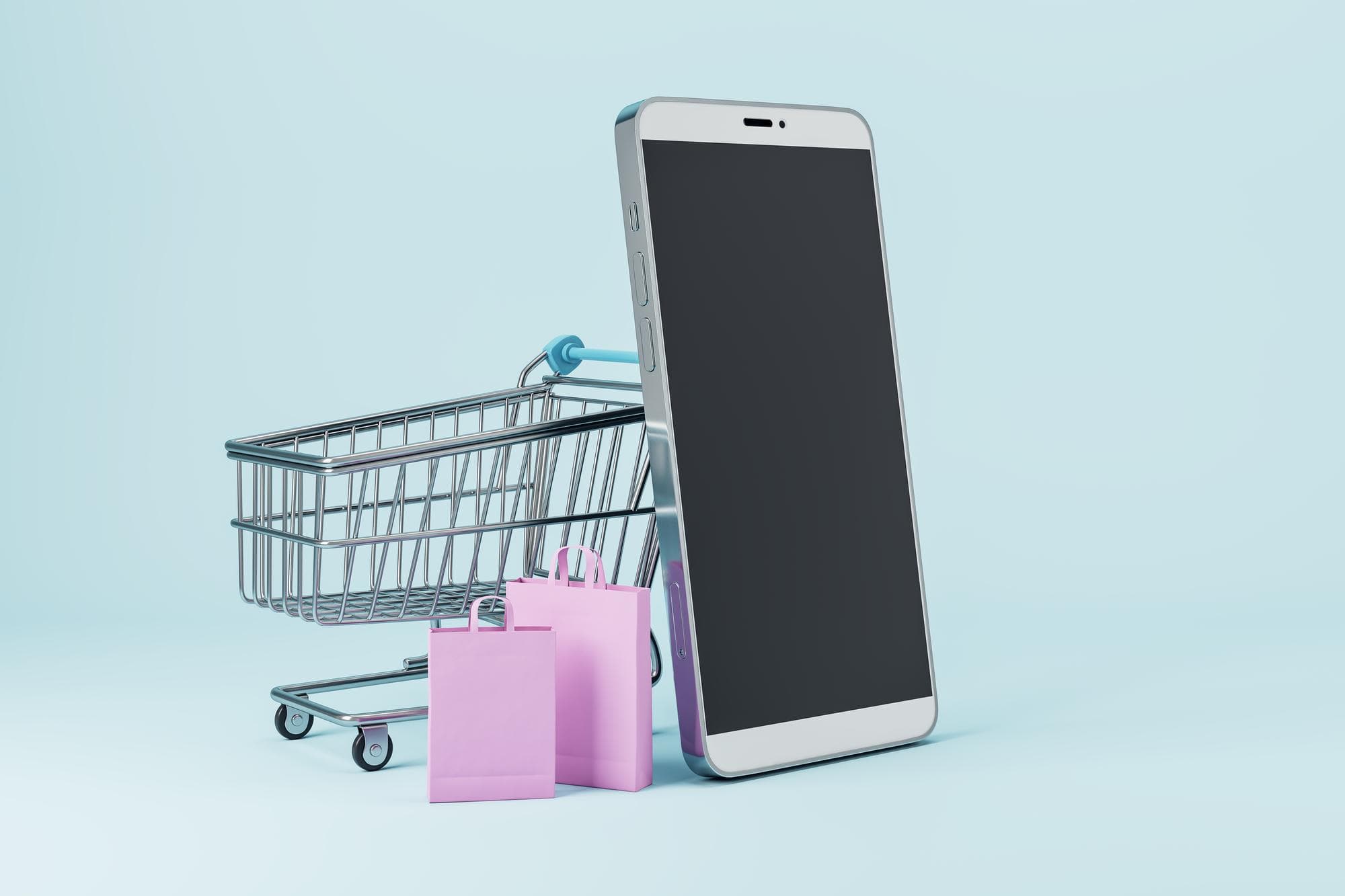 Shopping cart with bags beside a smartphone